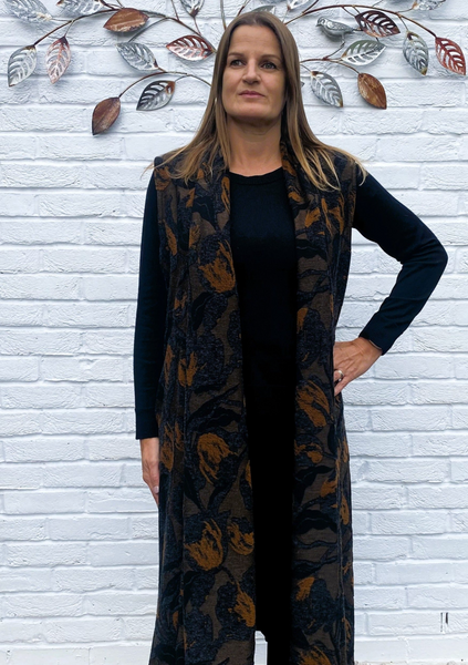 The sleeveless cardigan is made from a soft knitted cotton jacquard fabric. With an all over autumnal design. Perfect for any autumn winter occasion, from a wedding to a party and everyday wear. This cardigan will take you from day to night with effortless style and elegance. Available in Black, Grey, Blue, Port and Gold.